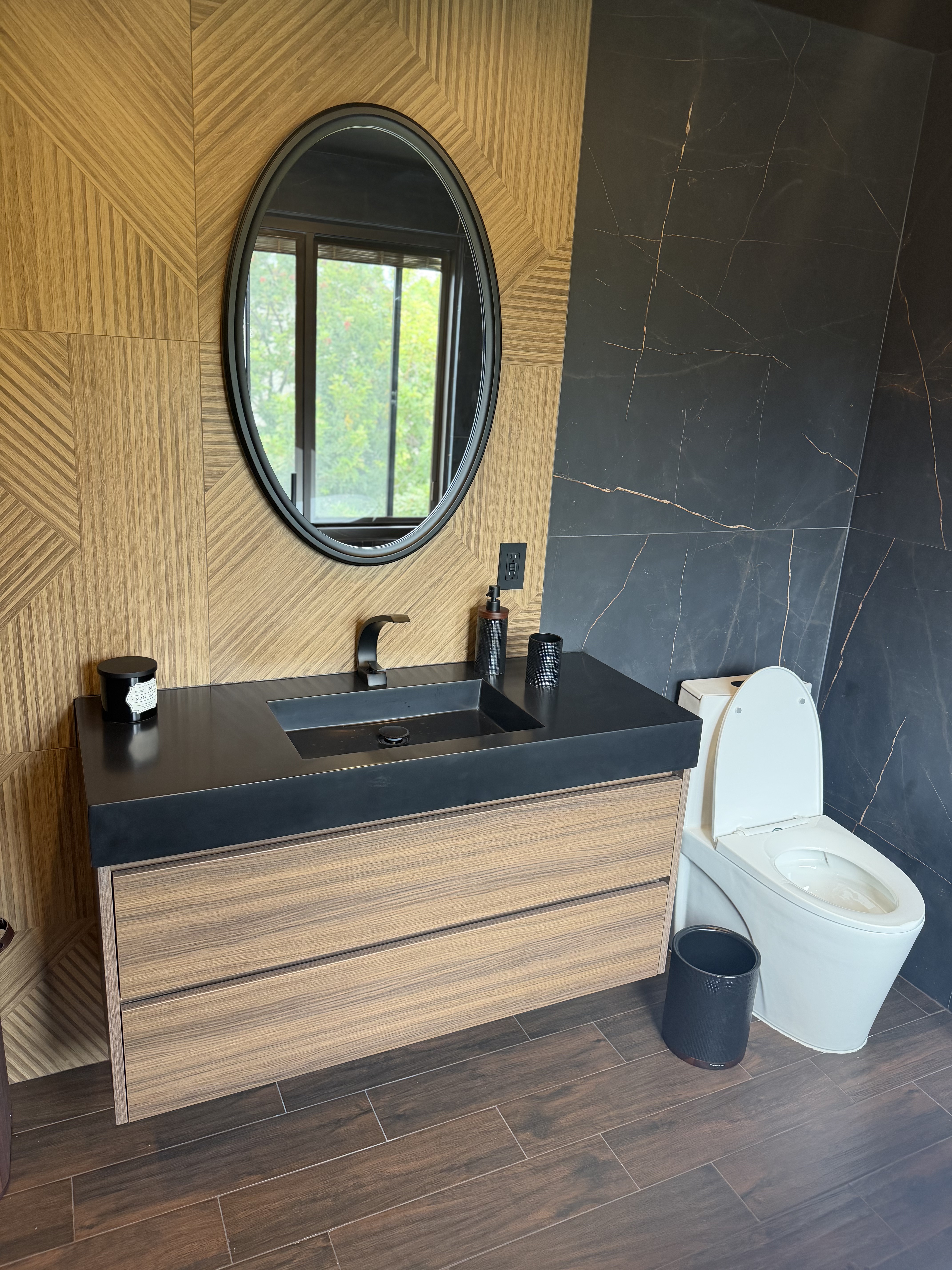 Bathroom remodel with matte black floating vanity and wood accent wall