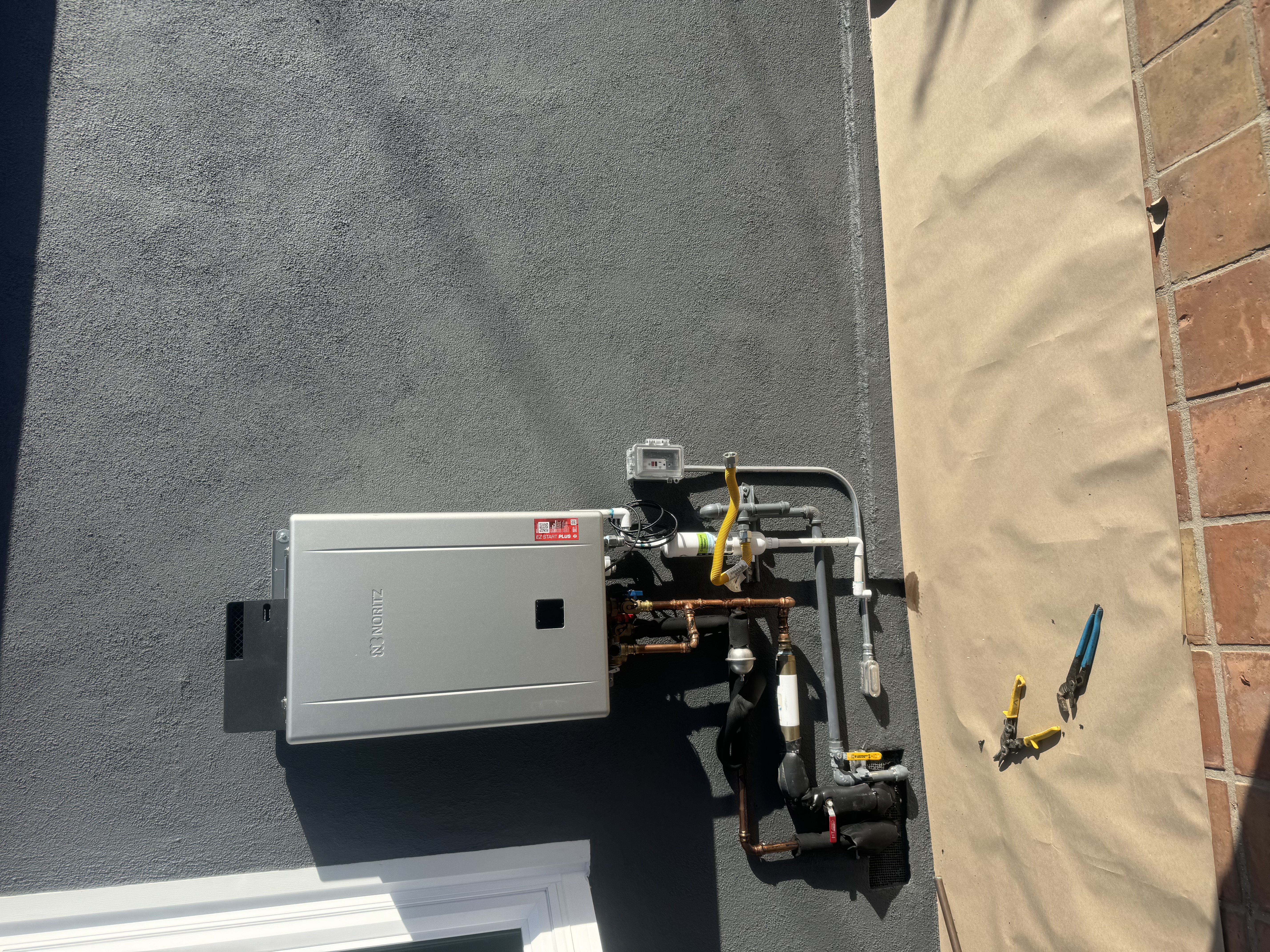 Noritz tankless water heater installed on exterior wall
